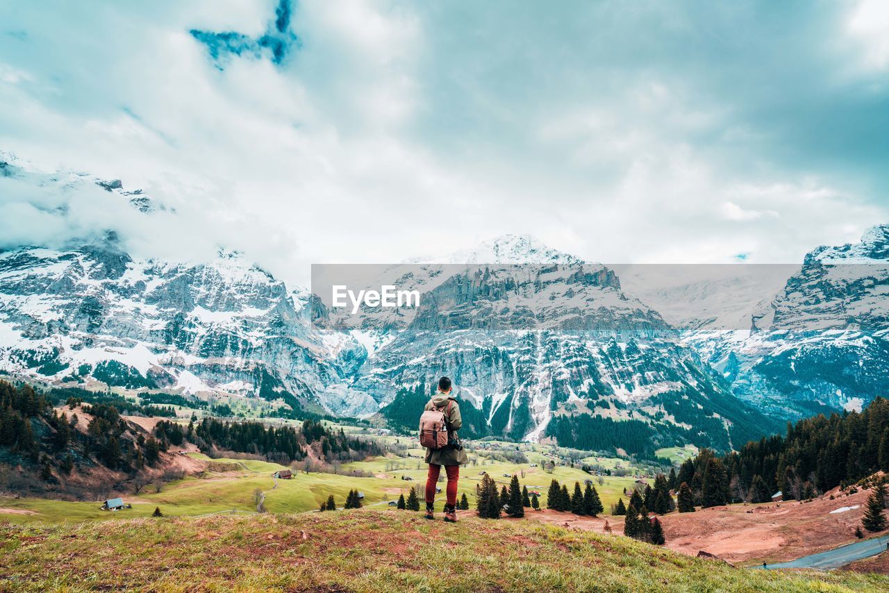 Full length of man looking at snowcapped mountain against sky