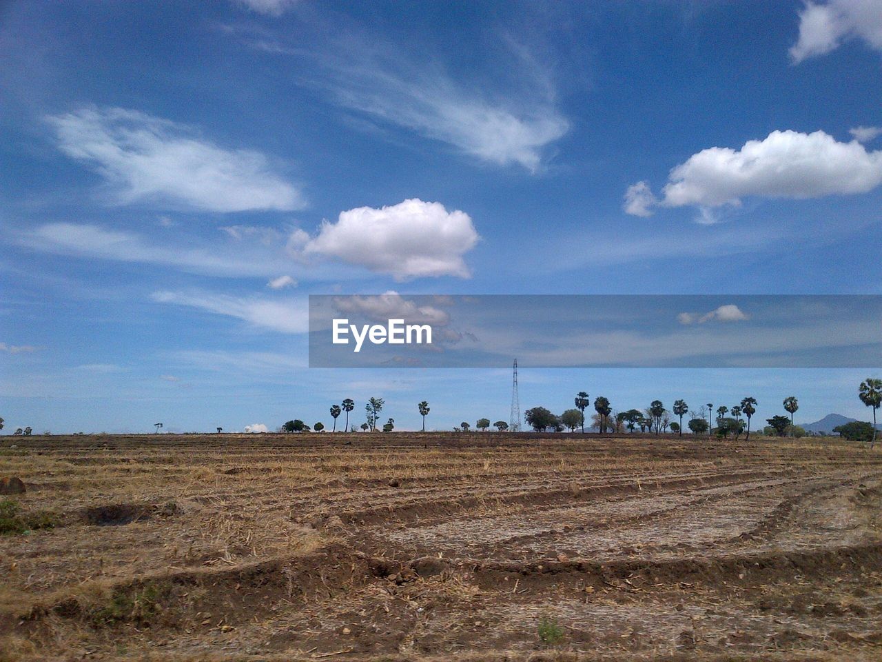 Scenic view of plough field against sky