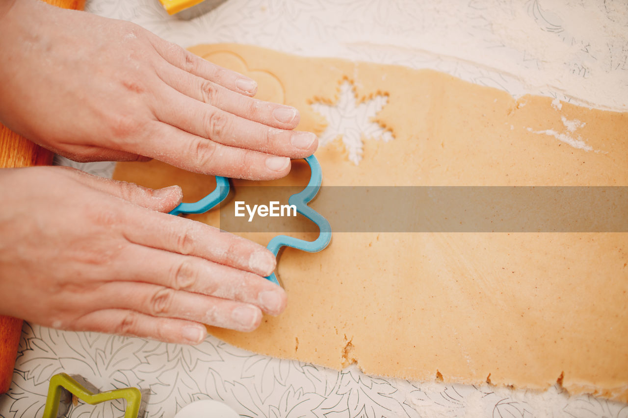 Cropped hands of woman making gingerbread cookie