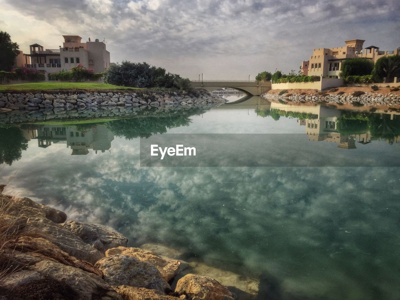 High angle view of river by buildings against cloudy sky