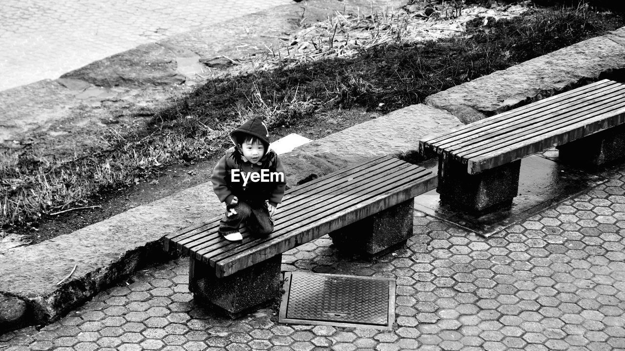 HIGH ANGLE VIEW OF WOMAN ON COBBLESTONE