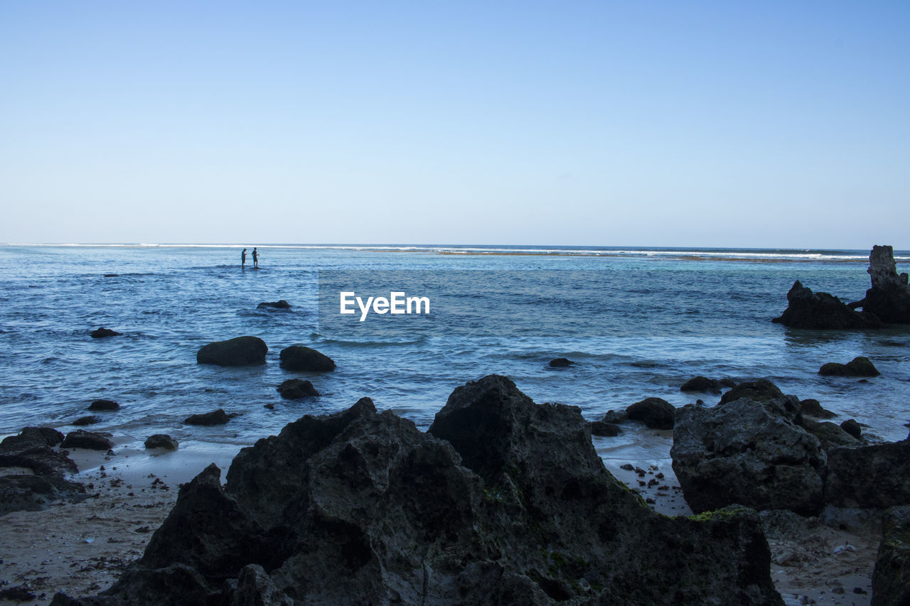 SCENIC VIEW OF ROCKS ON SEA AGAINST CLEAR SKY