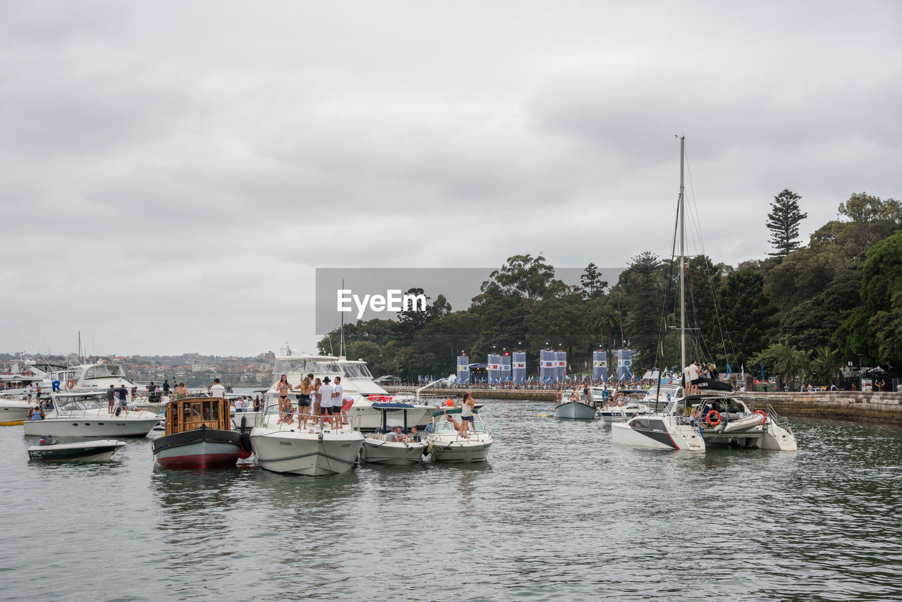 BOATS MOORED AT HARBOR AGAINST SKY