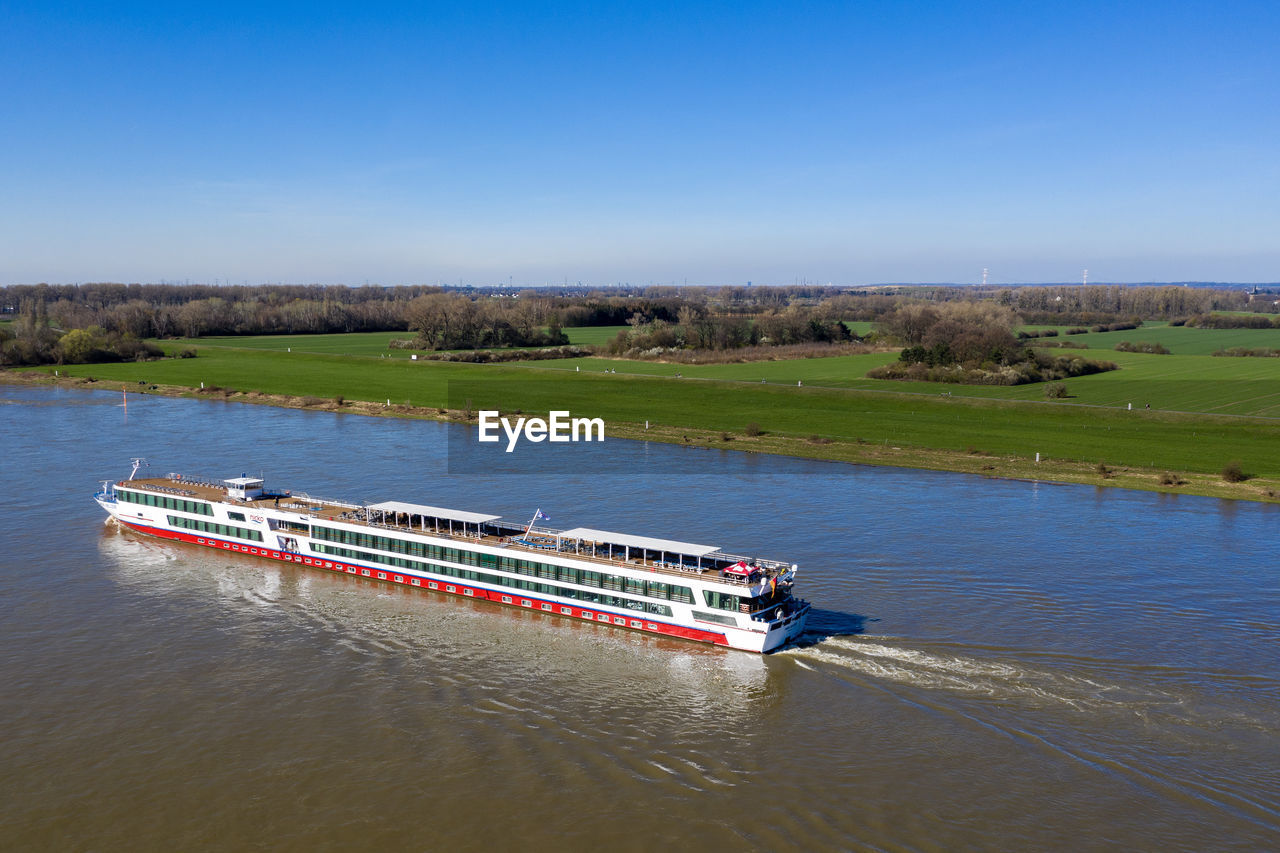 BOATS IN RIVER AGAINST SKY