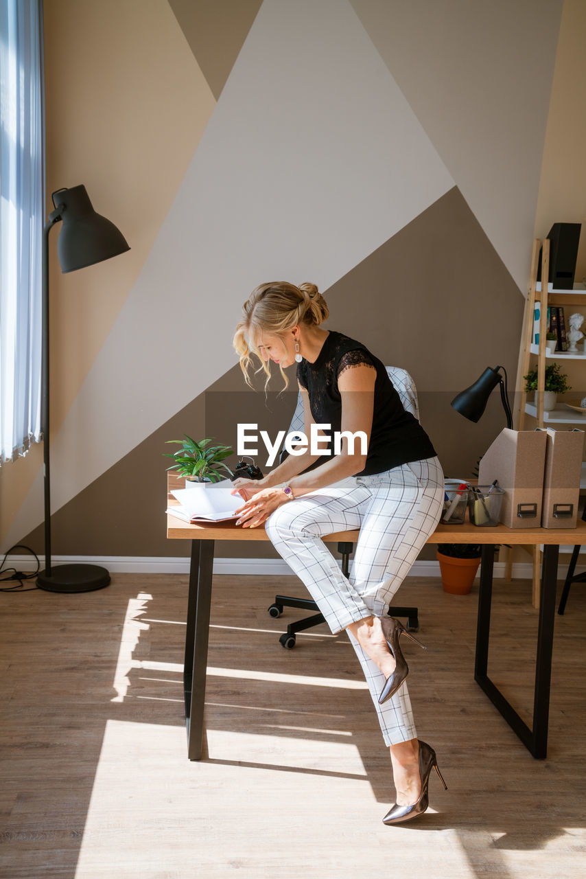 Pensive woman in office planning work schedule in notebook. sitting