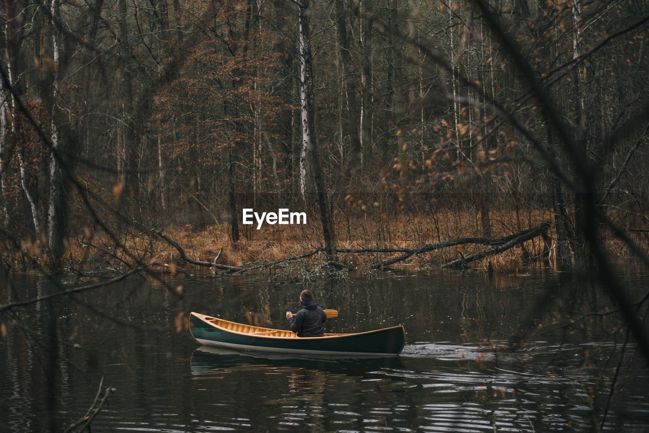 Rear view of man boating in lake