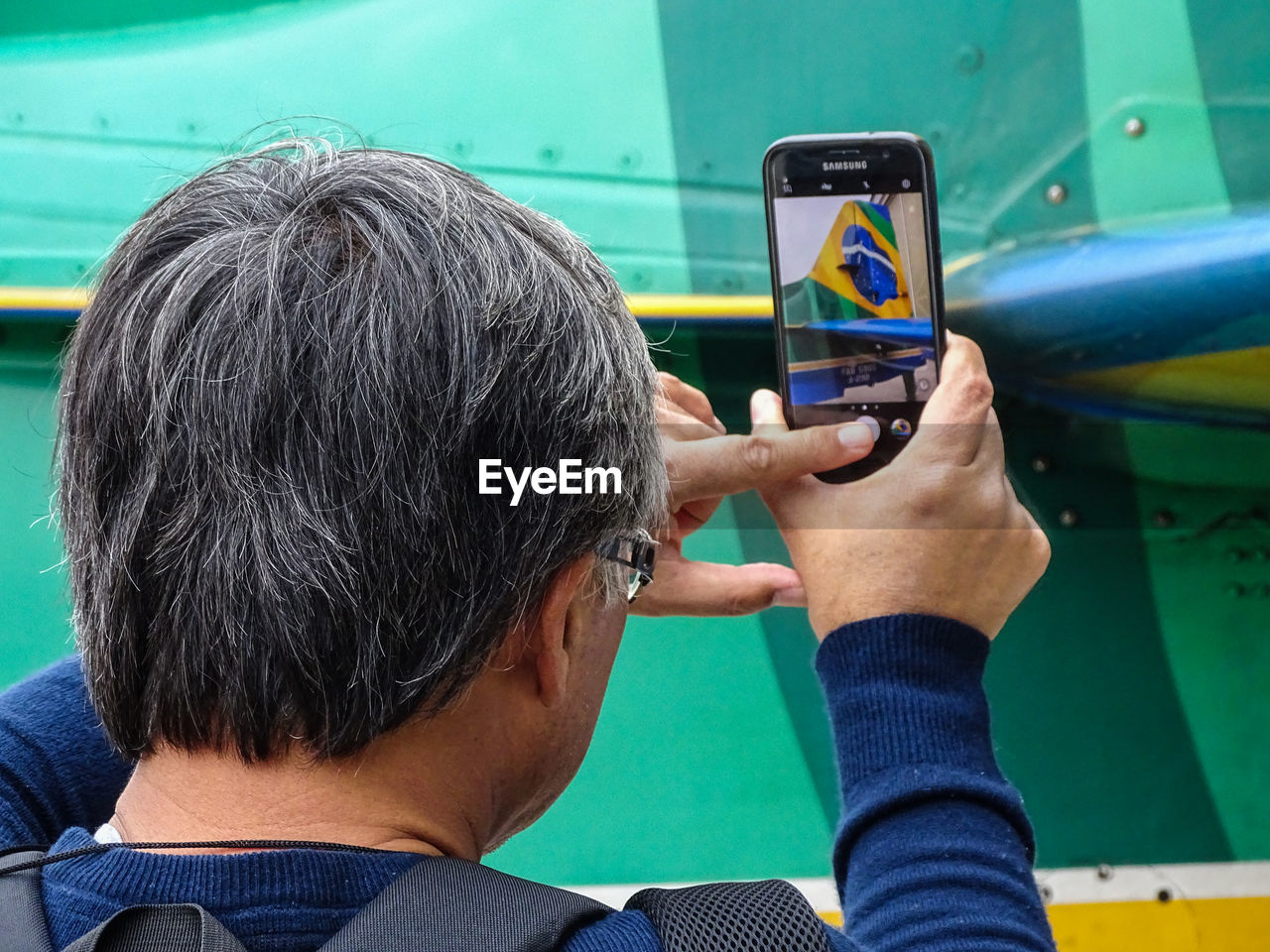 REAR VIEW PORTRAIT OF BOY USING SMART PHONE