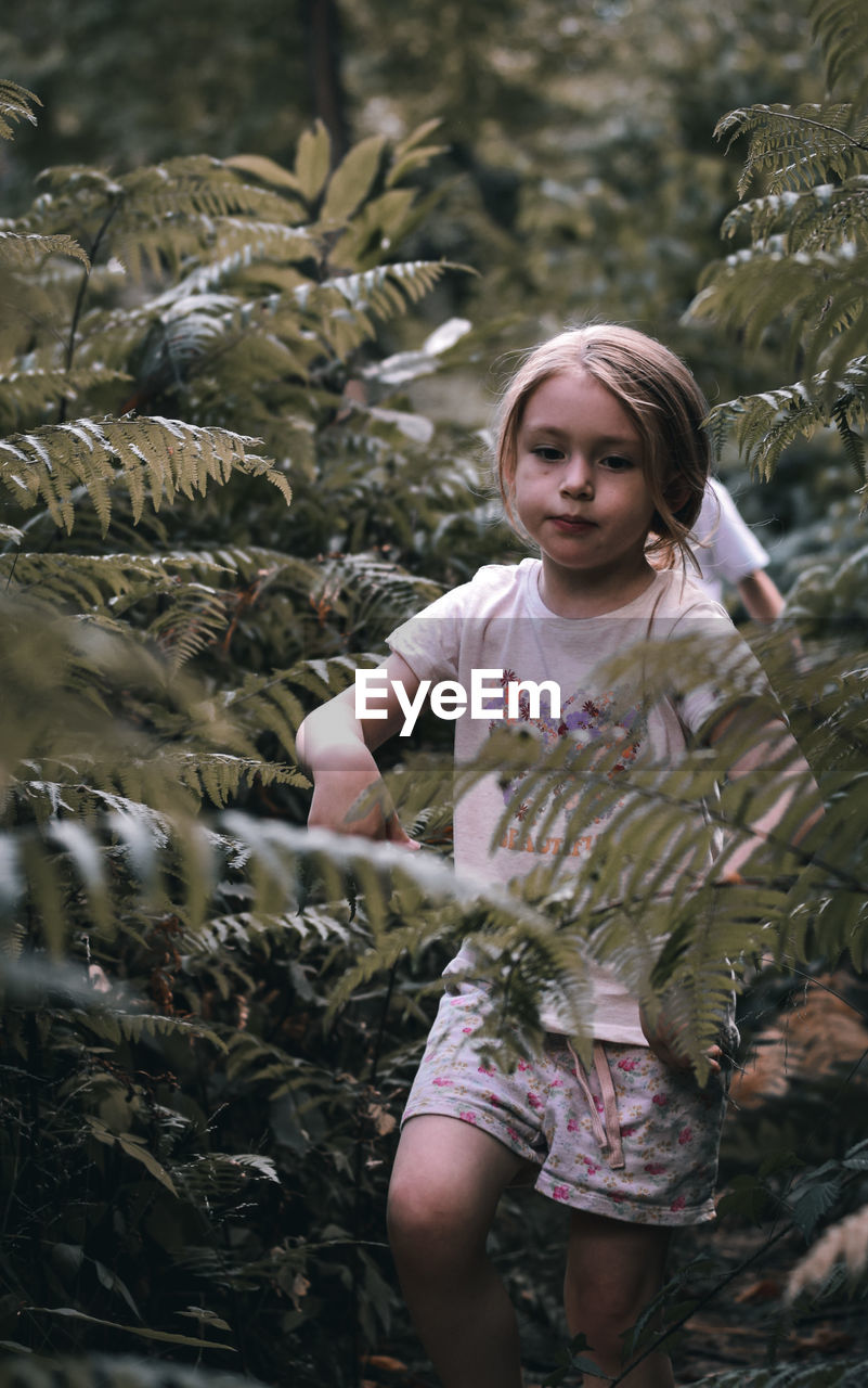 Girl walking through ferns 