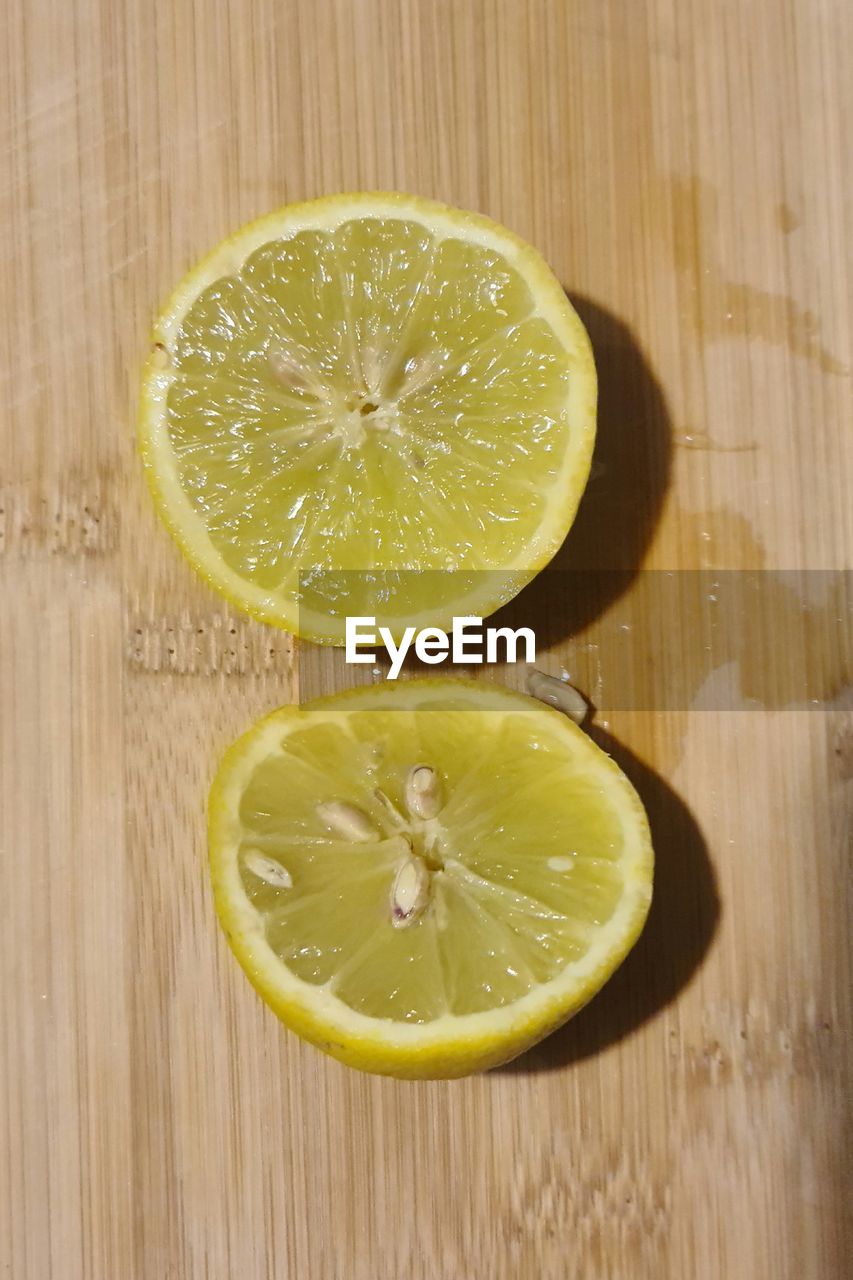 food and drink, healthy eating, food, fruit, slice, citrus fruit, citrus, plant, wellbeing, freshness, cross section, wood, lemon, produce, indoors, lime, no people, studio shot, halved, table, high angle view, still life, directly above, orange, refreshment, close-up, yellow, juicy