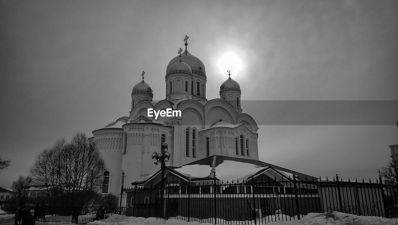 Black and white scenic view of a russian orthodox church, sun shining on top of a dome.