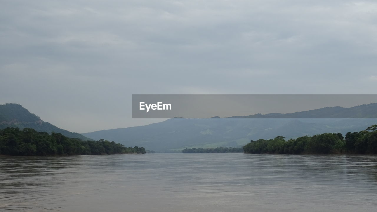 SCENIC VIEW OF LAKE BY MOUNTAIN AGAINST SKY