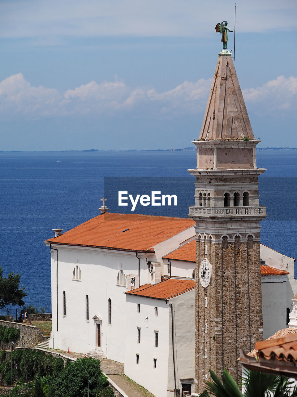 Traditional church by sea against sky