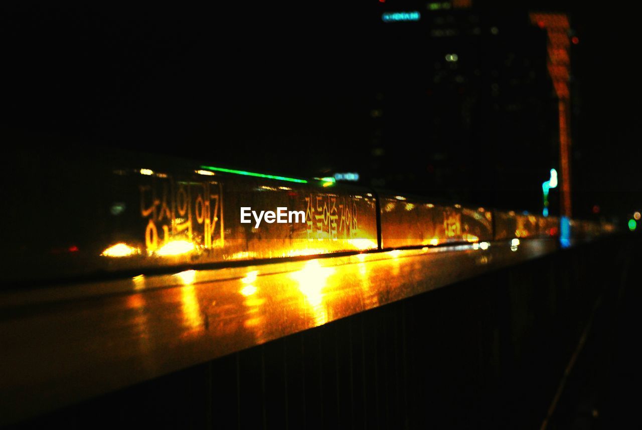 LIGHT TRAILS ON STREET AT NIGHT