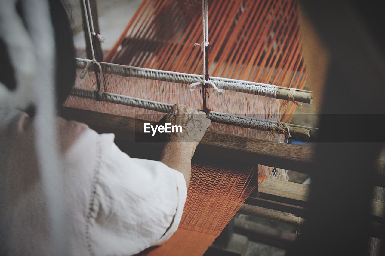 Cropped image of man using loom in textile industry