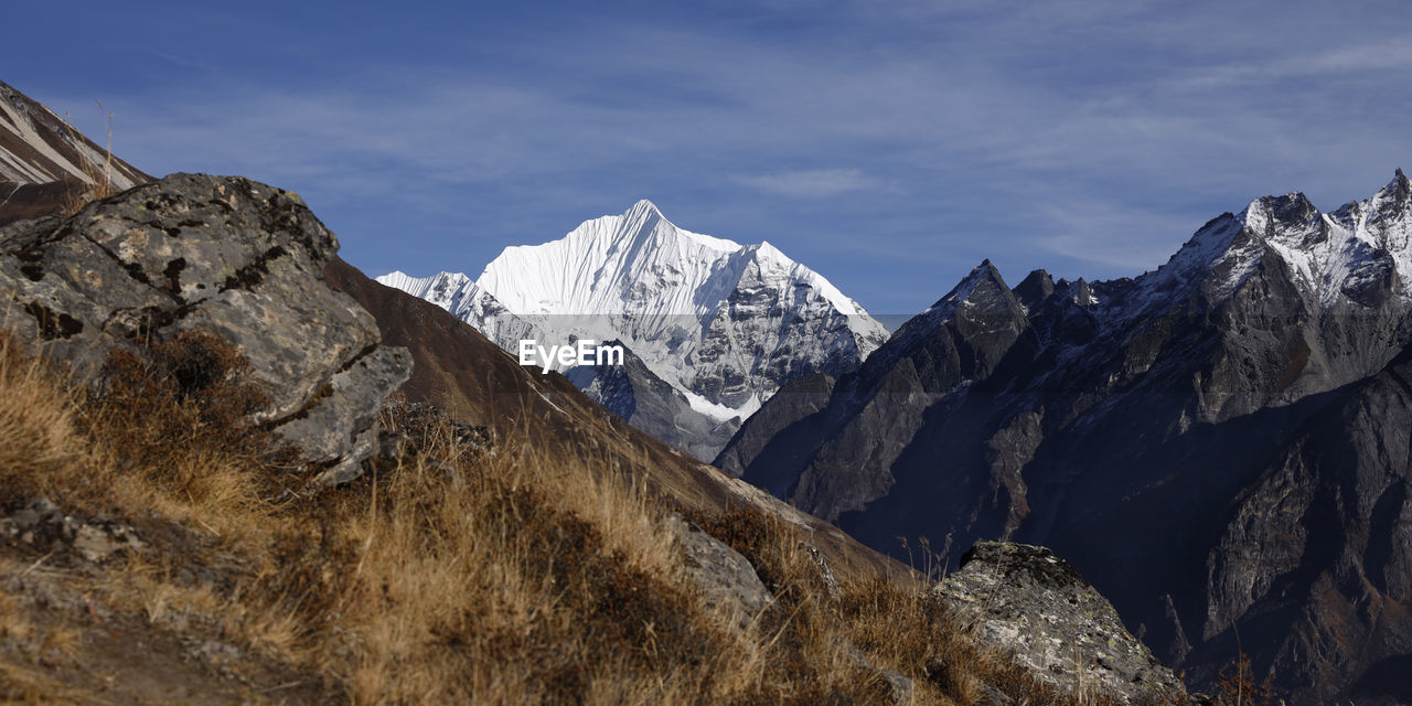 PANORAMIC VIEW OF SNOWCAPPED MOUNTAIN RANGE AGAINST SKY