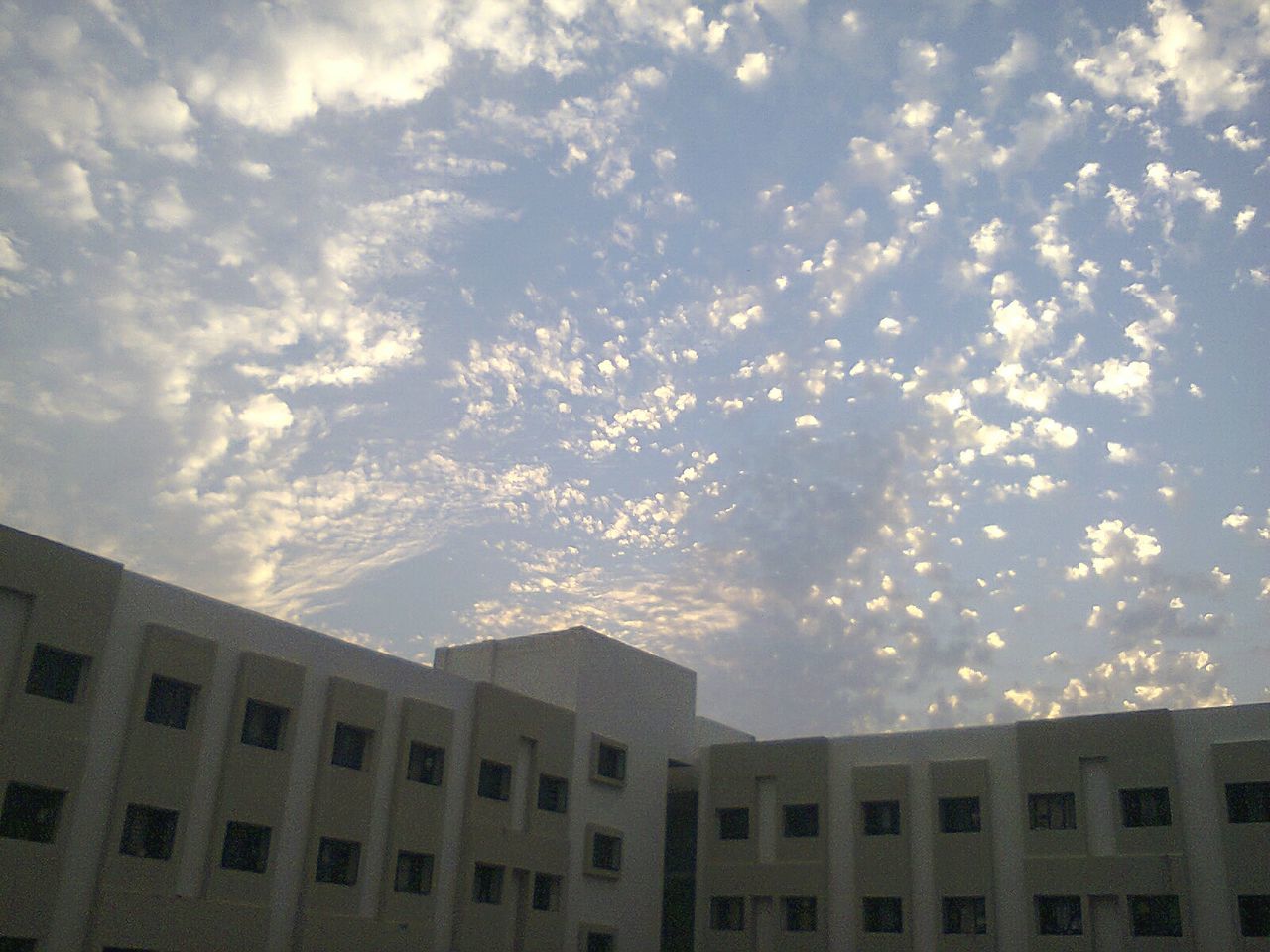 Low angle view of buildings against cloudy sky