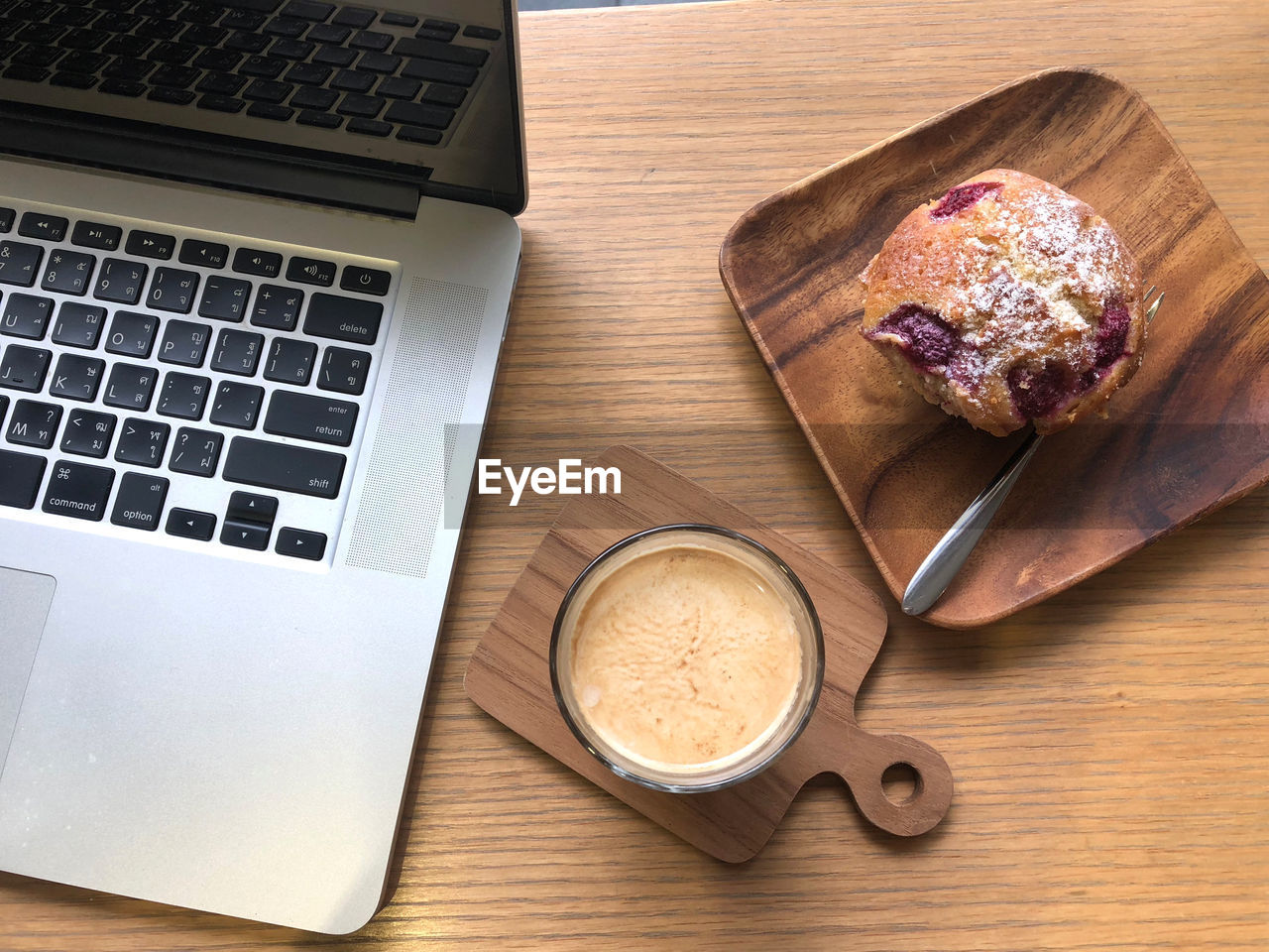 High angle view of coffee cup by laptop on table