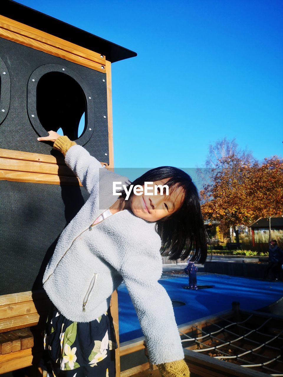 Cute asian girl playing at the playground during summer