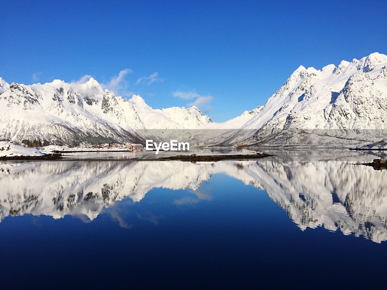 Scenic view of lake and mountains against blue sky