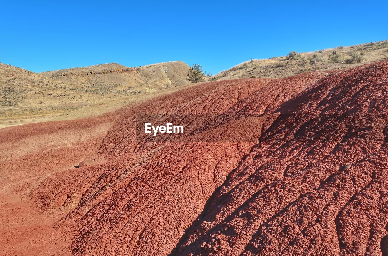 Scenic view of desert against clear blue sky