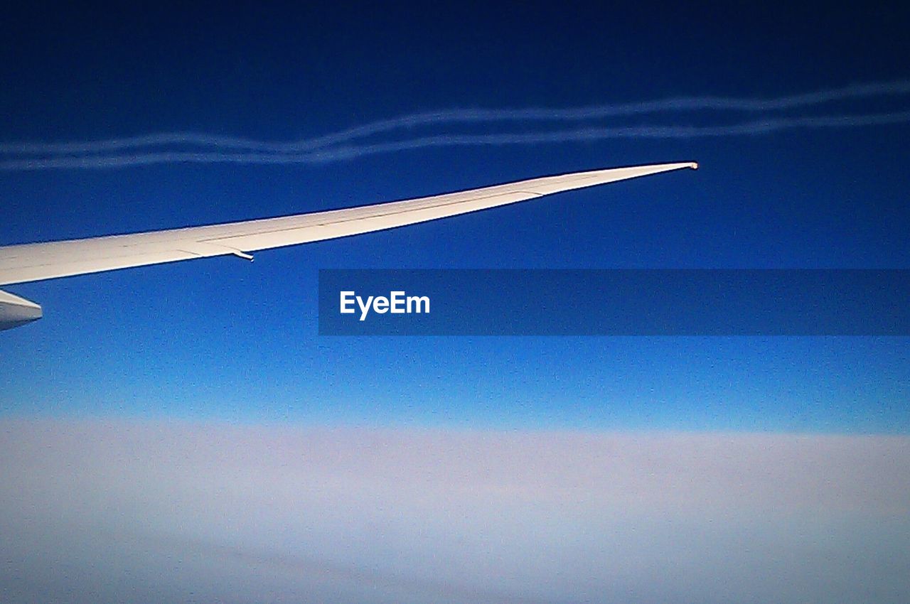 Close-up of airplane wing in sky