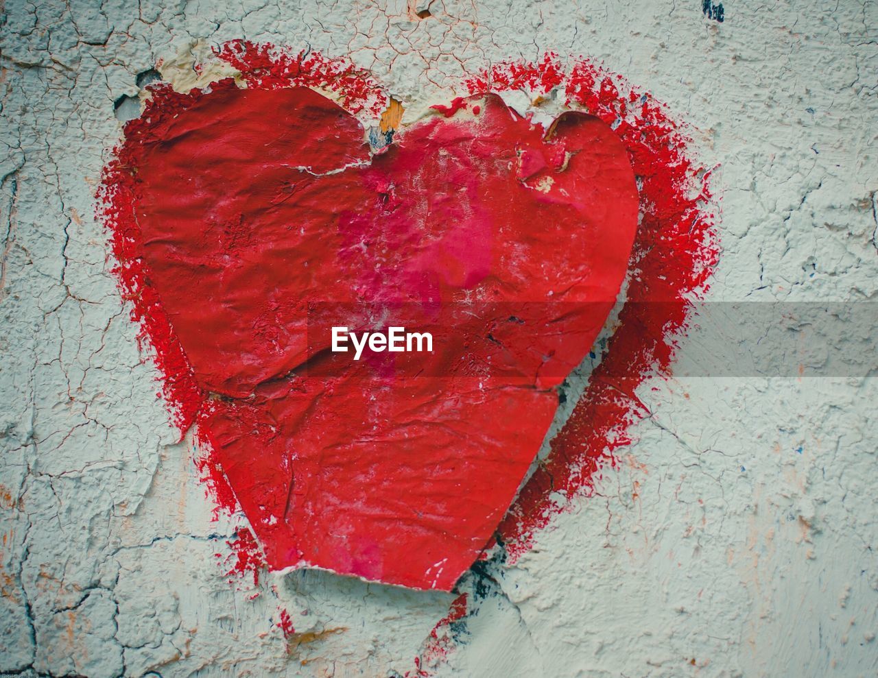 Close-up of red heart shape on white wall