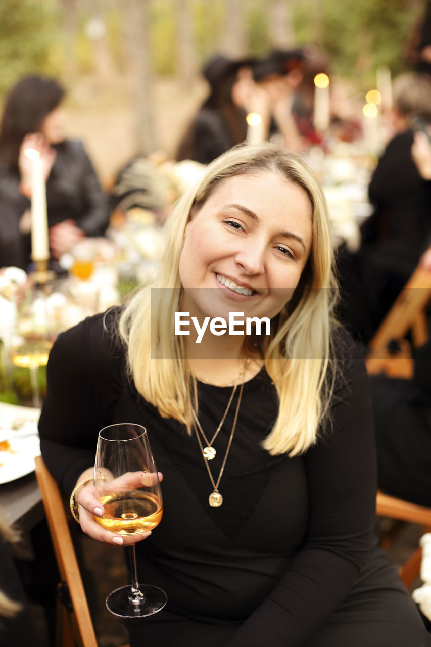 Portrait of smiling young woman with drink in restaurant