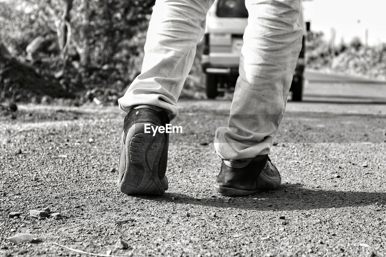 LOW SECTION OF MAN WALKING ON SIDEWALK