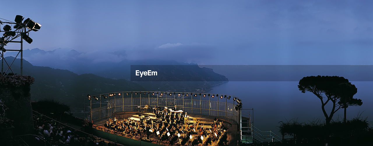 Panoramic view of illuminated mountains against sky at night