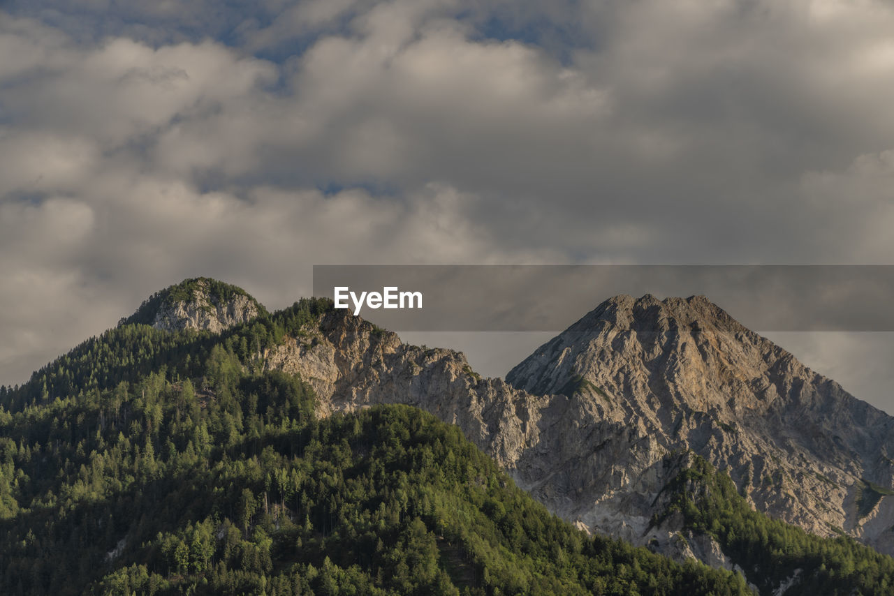 LOW ANGLE VIEW OF MOUNTAIN AGAINST CLOUDY SKY