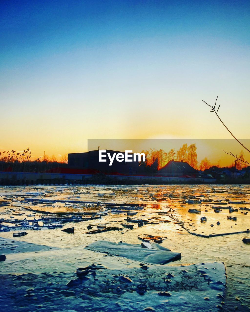 SCENIC VIEW OF LAKE AGAINST CLEAR SKY DURING SUNSET