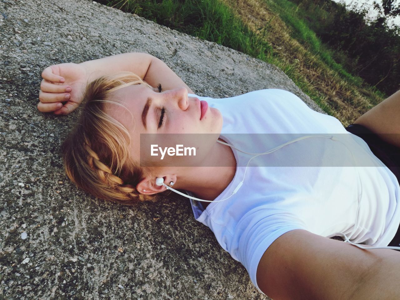 High angle view of woman sleeping on concrete