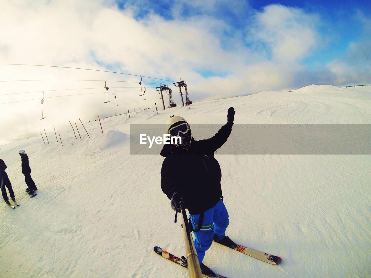 Skier taking selfie against cloudy sky