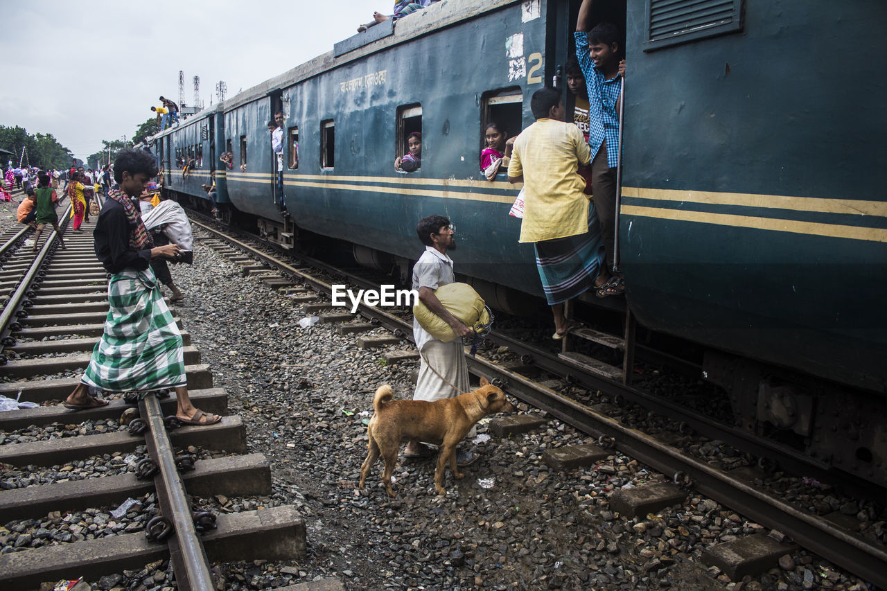 PEOPLE ON TRAIN AT RAILROAD STATION