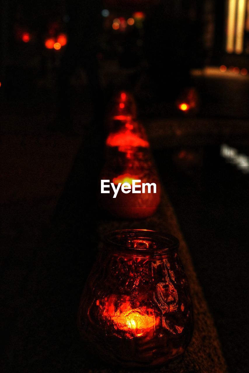 CLOSE-UP OF ILLUMINATED CANDLES IN DARK