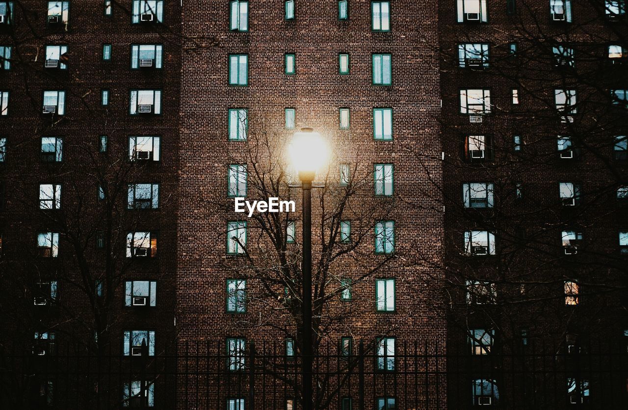 Illuminated street light against building