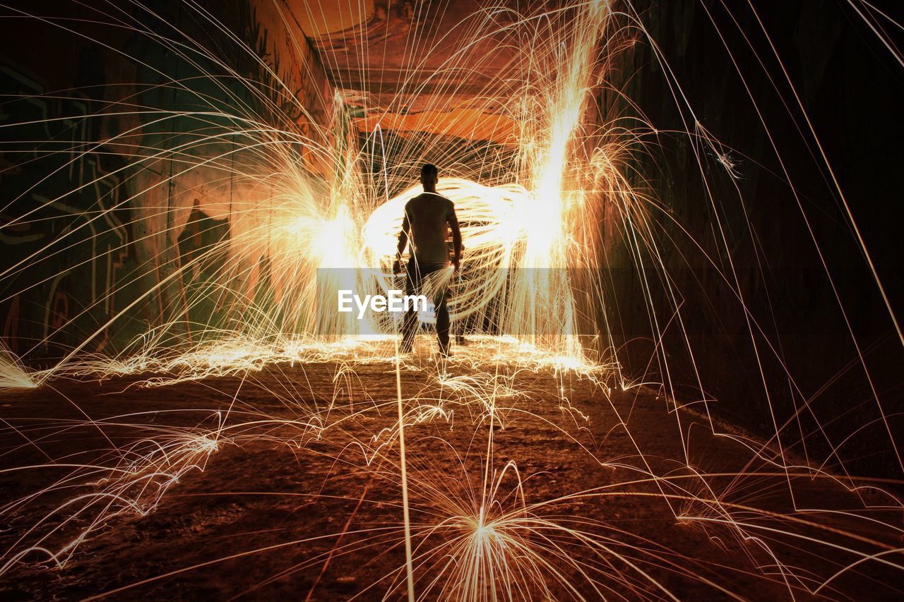 Rear view of man standing amidst wire wool