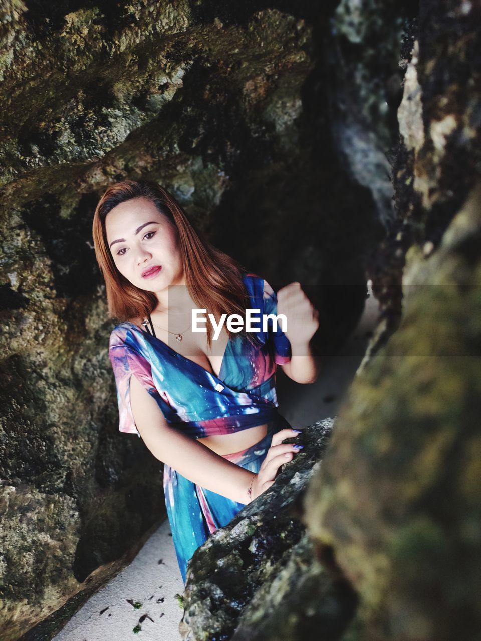 Portrait of a beautiful young woman standing on rock