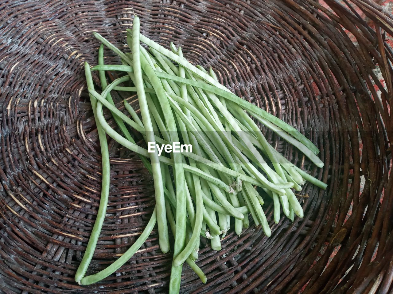 HIGH ANGLE VIEW OF VEGETABLES IN WICKER BASKET ON FLOOR