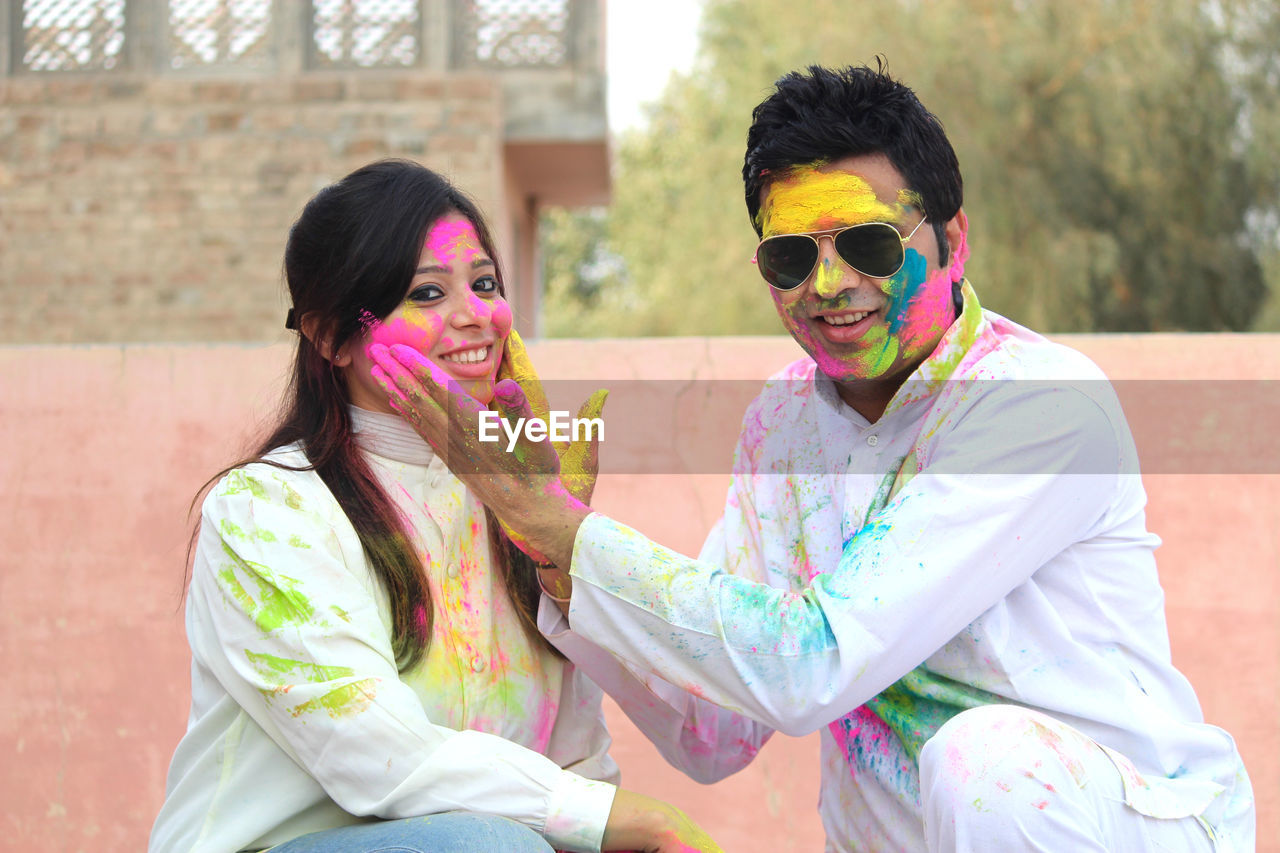 Portrait of smiling mid adult couple playing holi