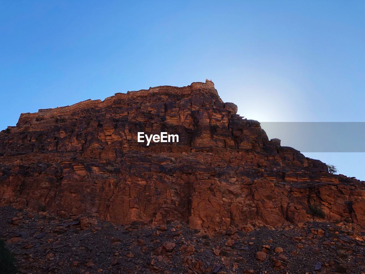 Low angle view of rock formation against clear blue sky