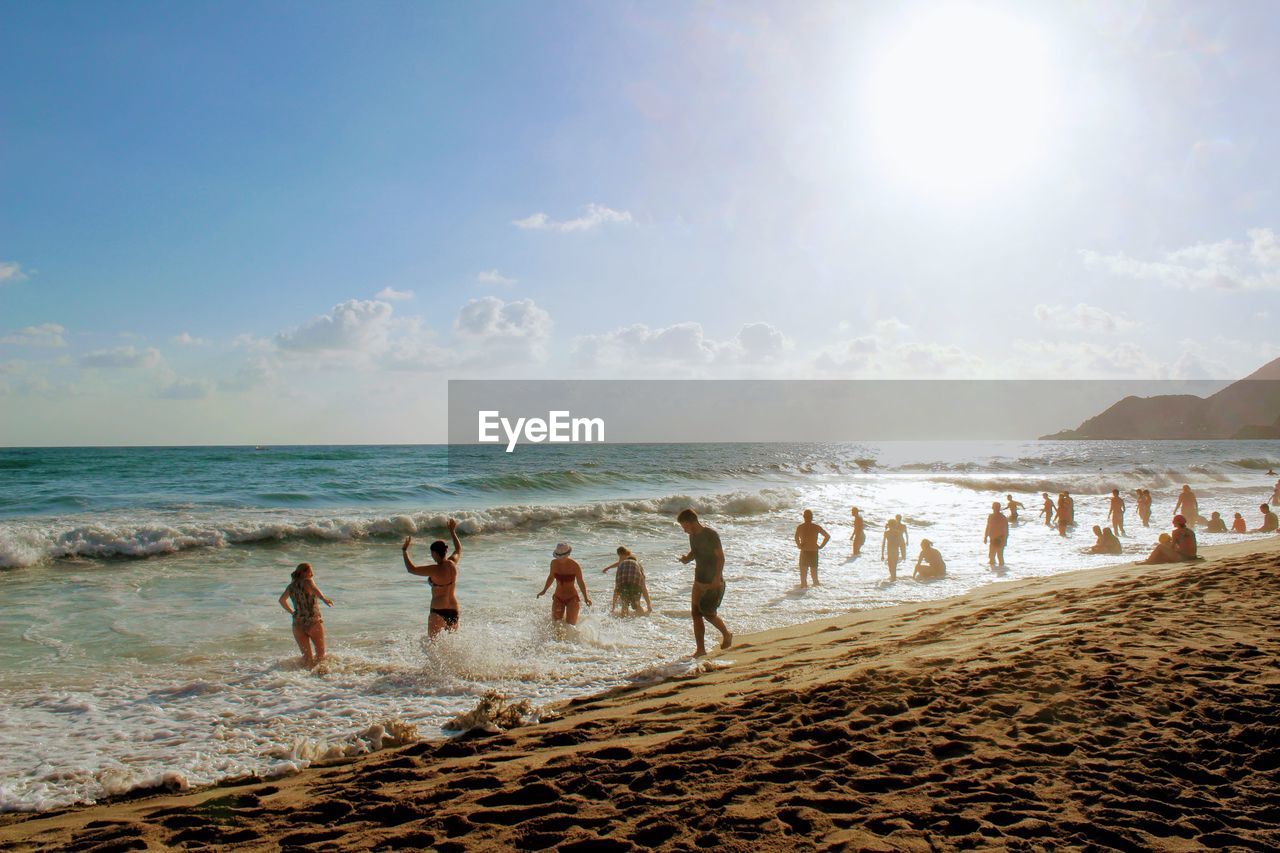 PEOPLE AT BEACH AGAINST SKY