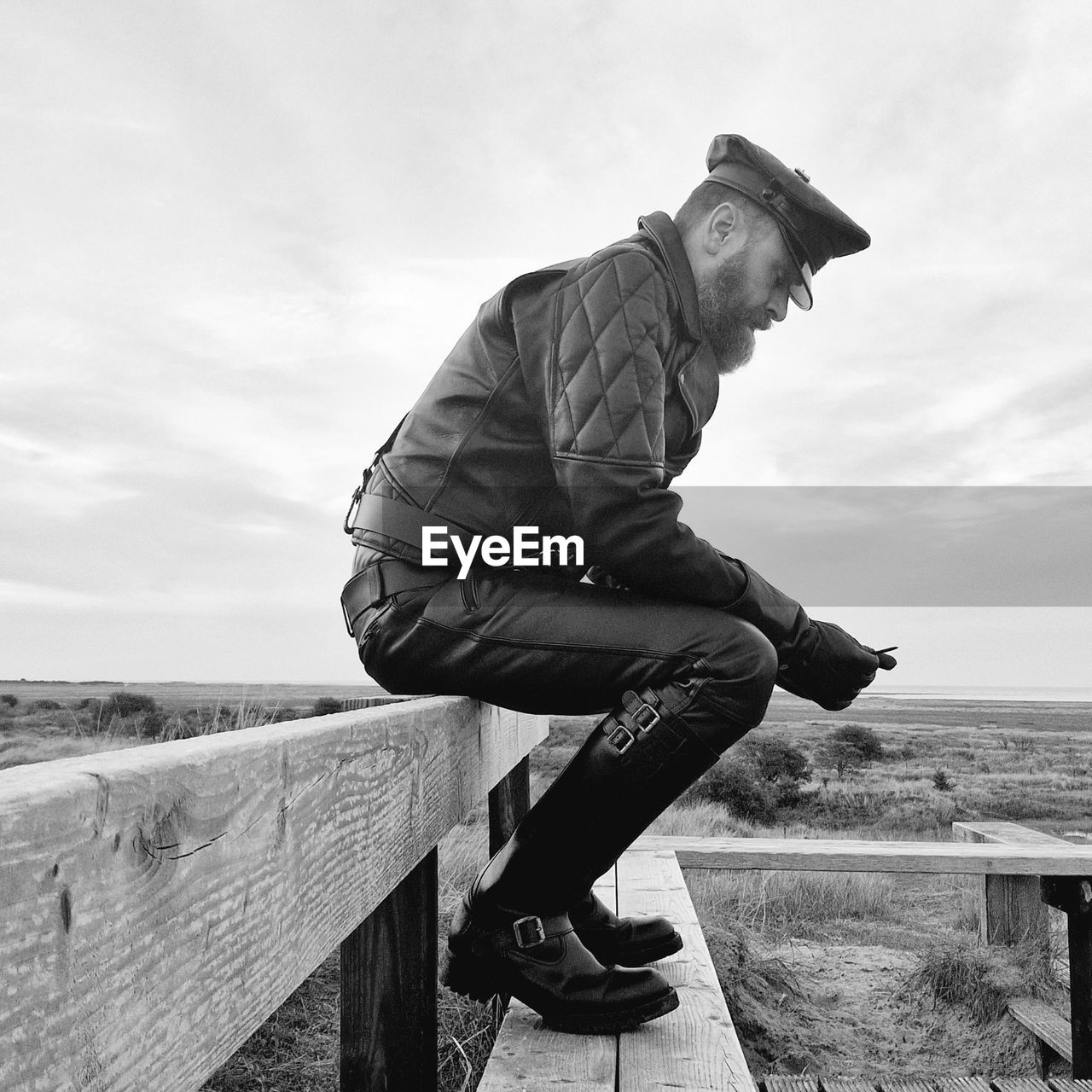  leather guy sitting on a bench