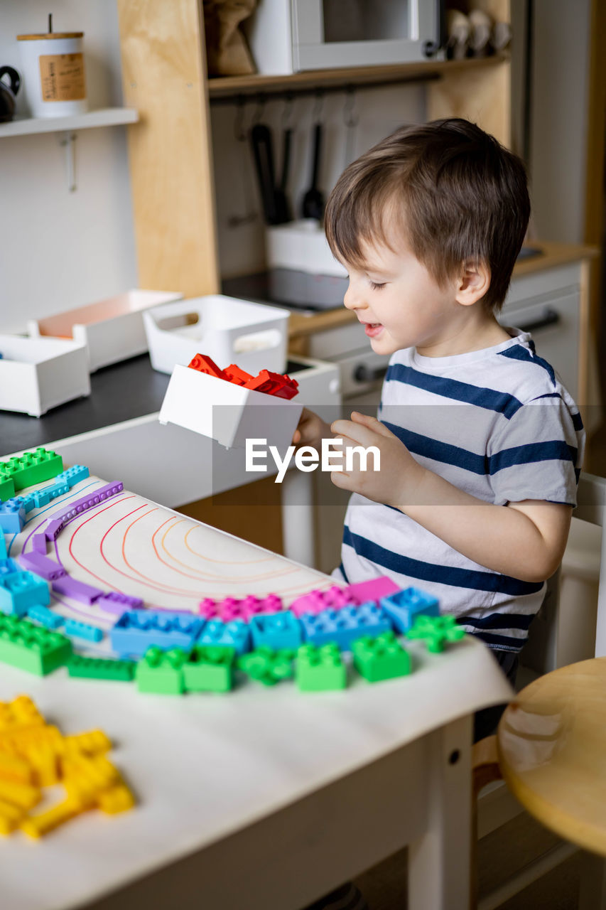 portrait of cute boy playing with toys at home