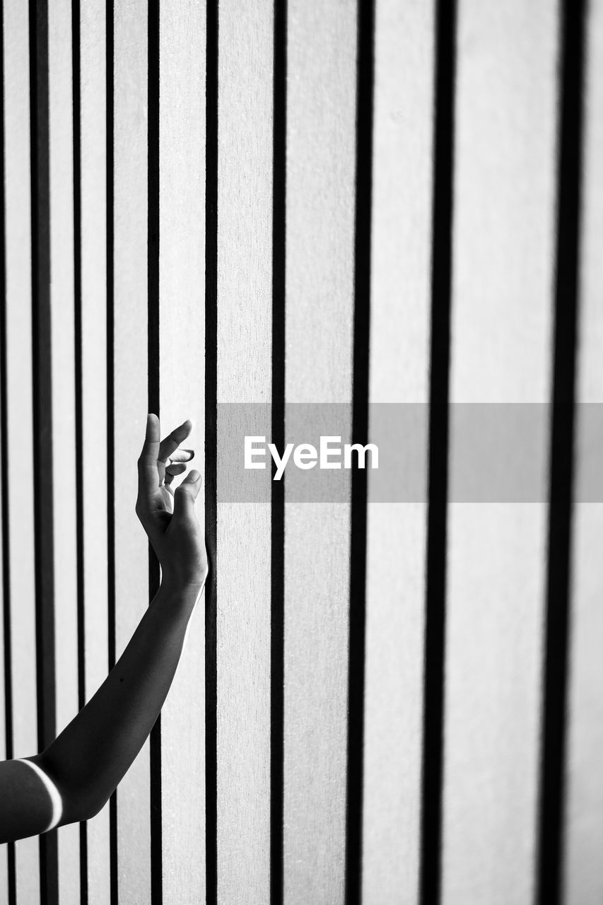 Human hand on railing against wall