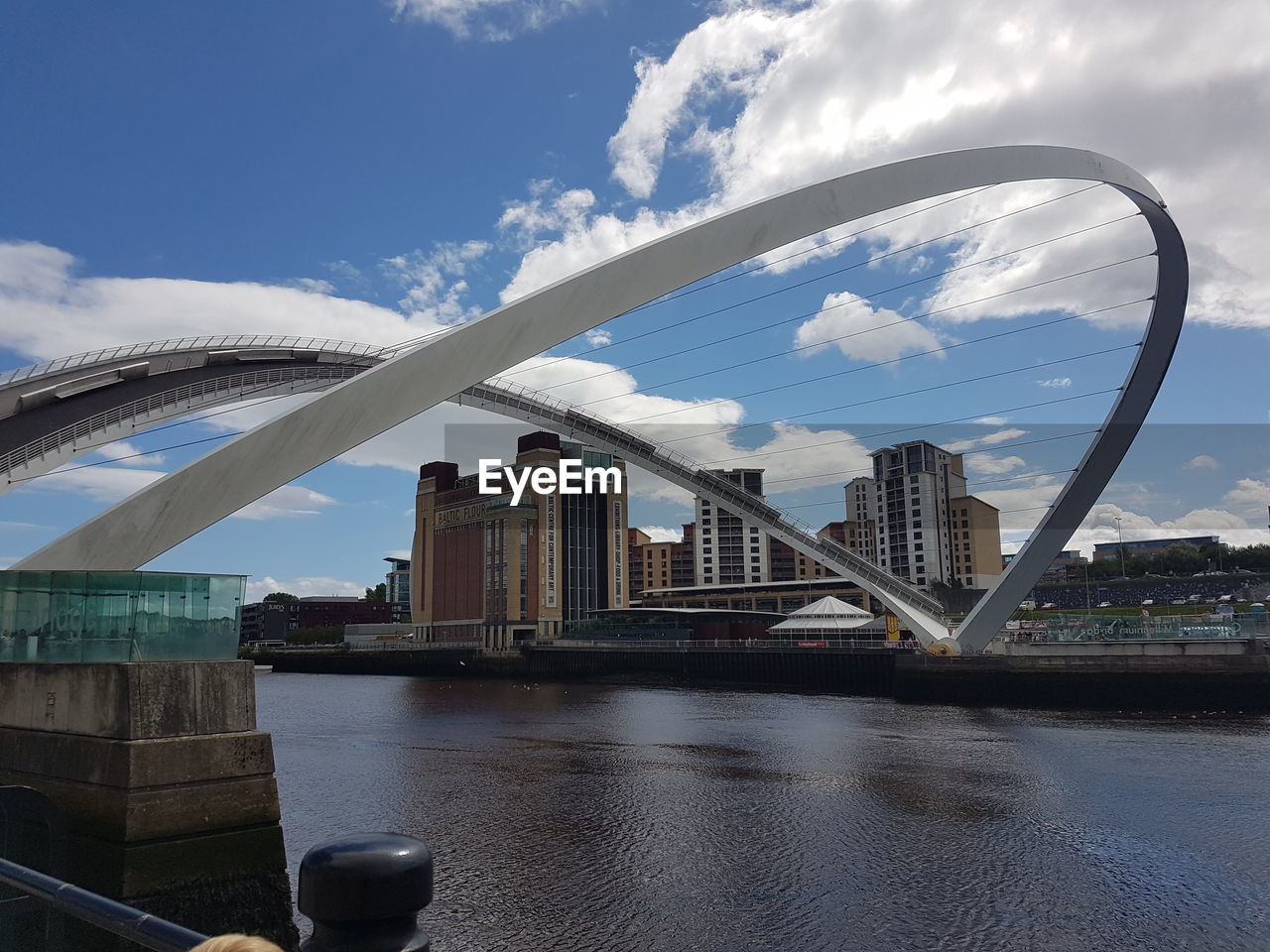 Bridge over river against sky in city