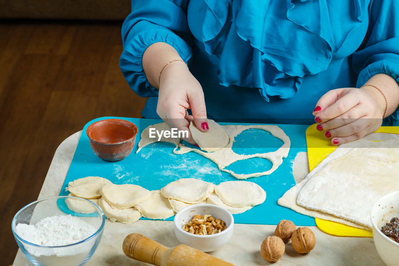 Women's hands make blanks from the dough gomentash biscuits with poppy seeds, traditional