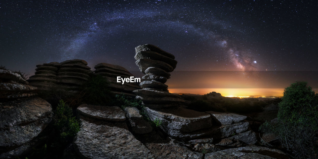 Majestic scenery of rocky terrain with colorful milky way on background in iceland