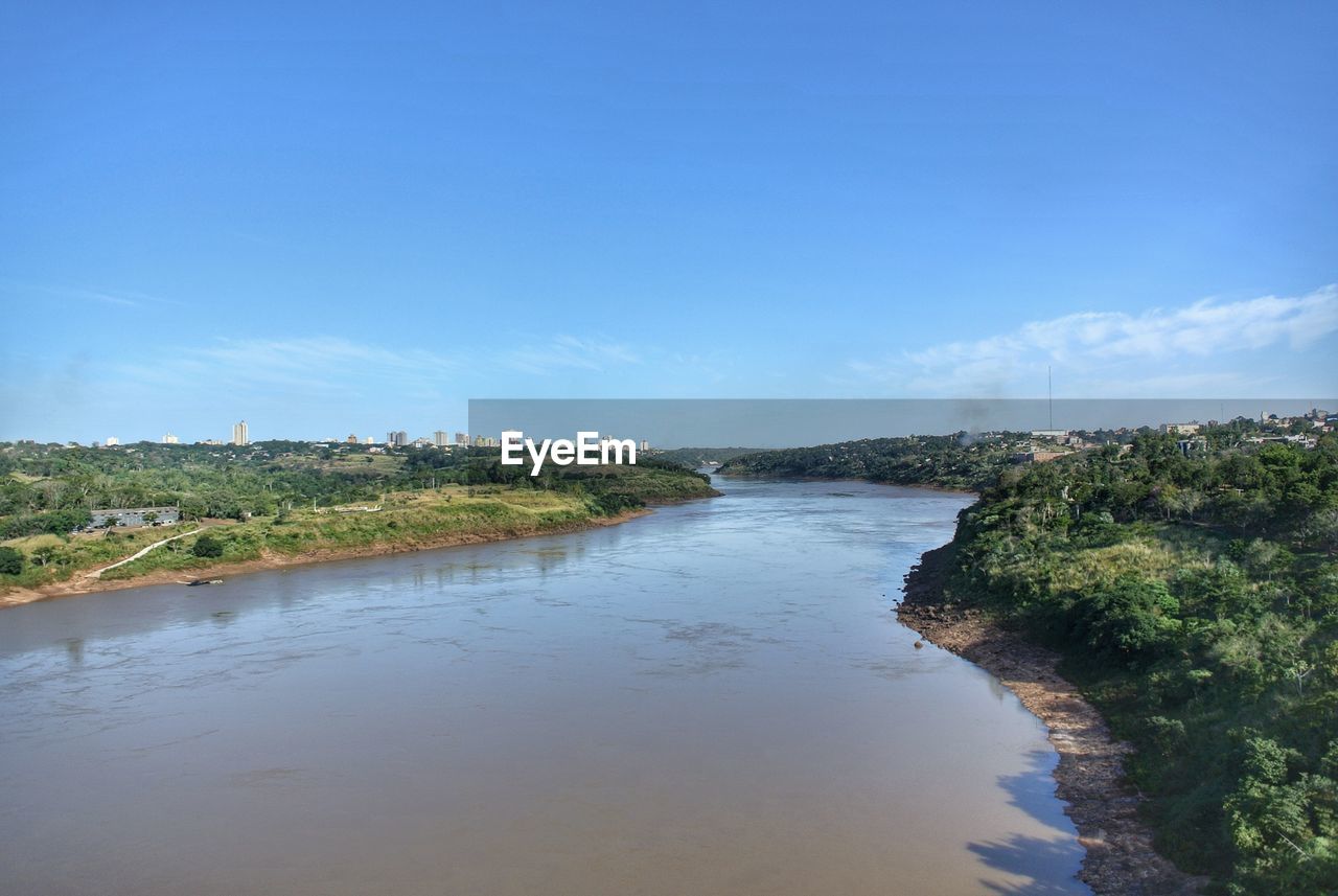 Scenic view of river against blue sky