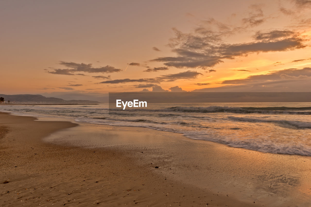 Scenic view of beach against sky during sunset